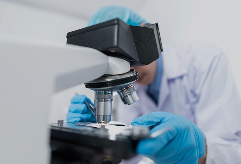 Médico analizando una muestra en un microscopio