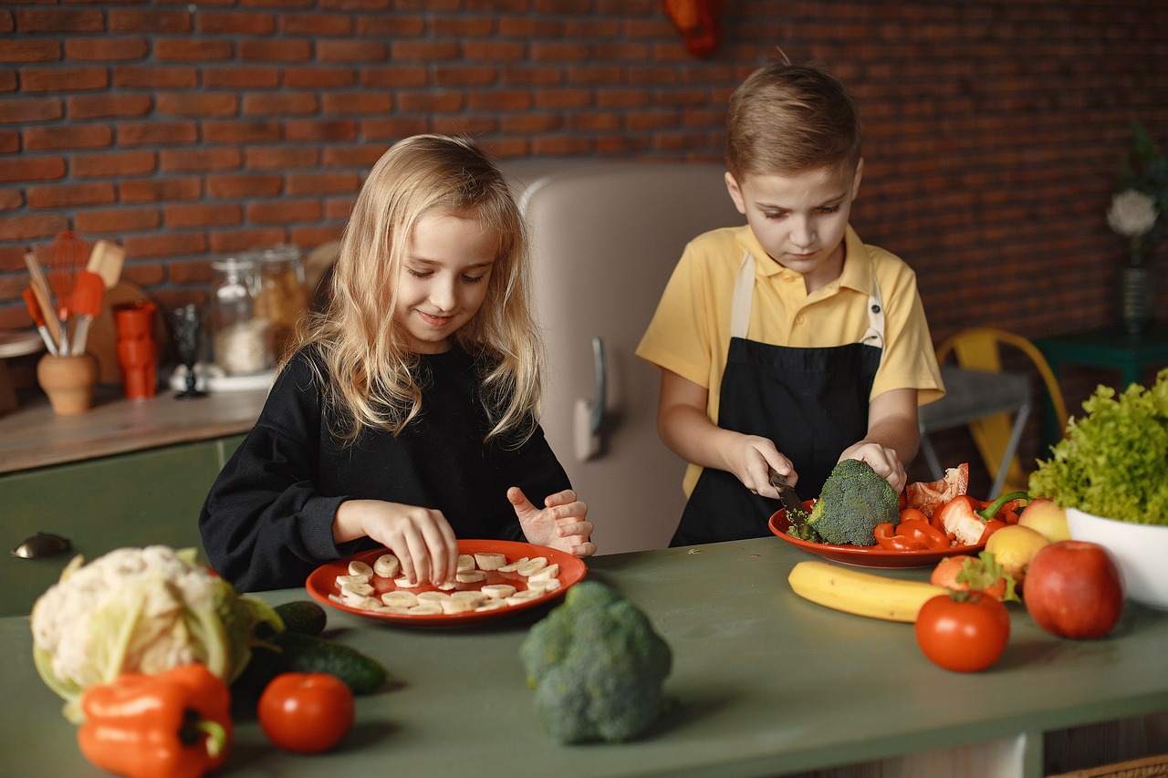 Un niño y una niña cocinando con frutas y verduras
